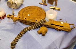 На переднем плане — диск и лента пулемёта ДП (Дегтярёва пехотный), корпус пистолета пулемёта Шпагина (ППШ-41) и оружейная маслёнка